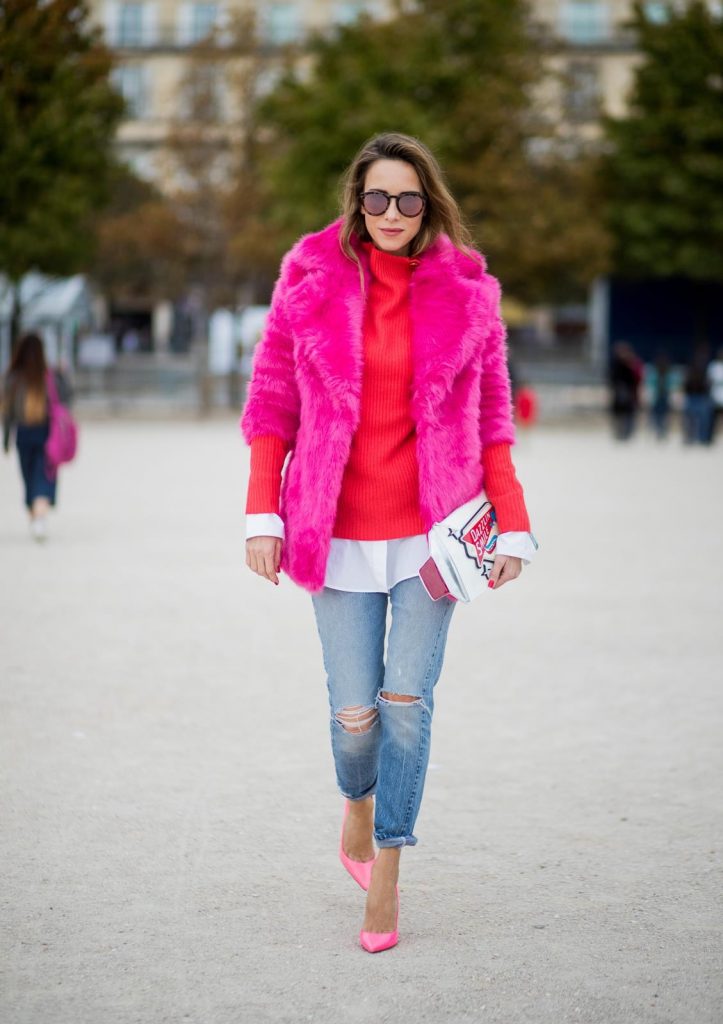 Alexandra Lapp wearing a fake fur jacket in pink from Jakke with a Faux Real statement on the back, red cashmere jumper by Heartbreaker with golden buttons, a long white blouse by Celine, Levis ReDone denim, Christian Louboutin heels in neon pink, sunglasses by Le Specs and a clutch by Yazburkey with a Dazzlin Smile application is seen during Paris Fashion Week Spring/Summer 2018 on September 27, 2017 in Paris, France.