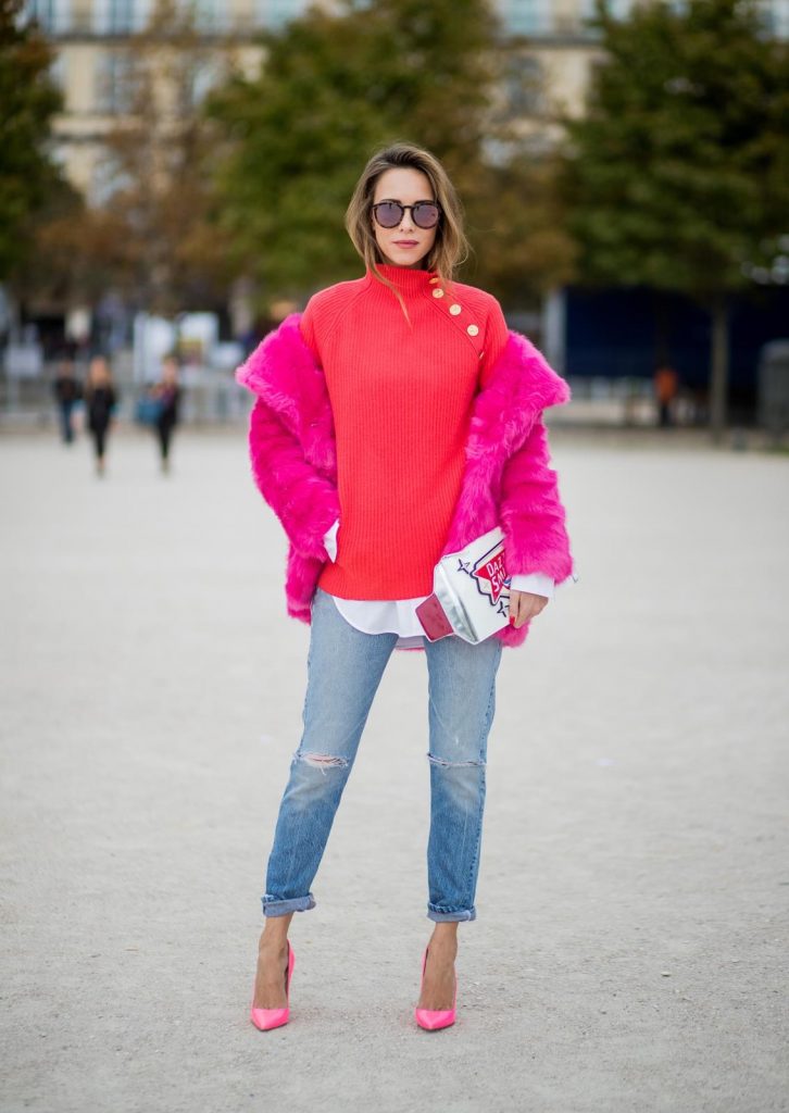 Alexandra Lapp wearing a fake fur jacket in pink from Jakke with a Faux Real statement on the back, red cashmere jumper by Heartbreaker with golden buttons, a long white blouse by Celine, Levis ReDone denim, Christian Louboutin heels in neon pink, sunglasses by Le Specs and a clutch by Yazburkey with a Dazzlin Smile application is seen during Paris Fashion Week Spring/Summer 2018 on September 27, 2017 in Paris, France.