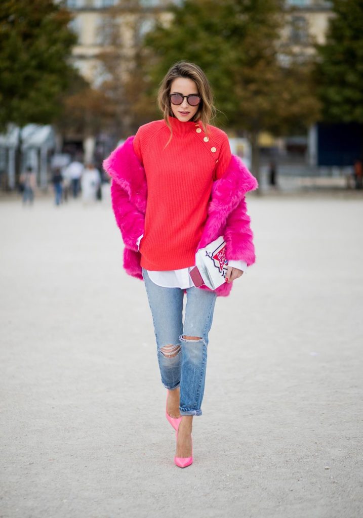 Alexandra Lapp wearing a fake fur jacket in pink from Jakke with a Faux Real statement on the back, red cashmere jumper by Heartbreaker with golden buttons, a long white blouse by Celine, Levis ReDone denim, Christian Louboutin heels in neon pink, sunglasses by Le Specs and a clutch by Yazburkey with a Dazzlin Smile application is seen during Paris Fashion Week Spring/Summer 2018 on September 27, 2017 in Paris, France.