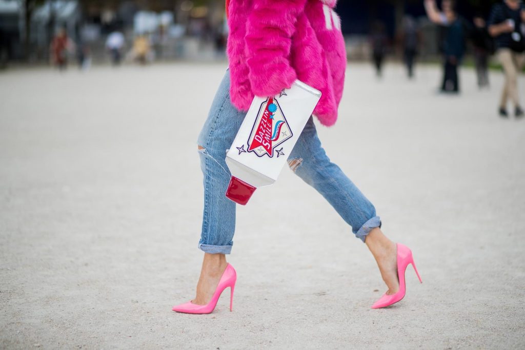 Alexandra Lapp wearing a fake fur jacket in pink from Jakke with a Faux Real statement on the back, red cashmere jumper by Heartbreaker with golden buttons, a long white blouse by Celine, Levis ReDone denim, Christian Louboutin heels in neon pink, sunglasses by Le Specs and a clutch by Yazburkey with a Dazzlin Smile application is seen during Paris Fashion Week Spring/Summer 2018 on September 27, 2017 in Paris, France.