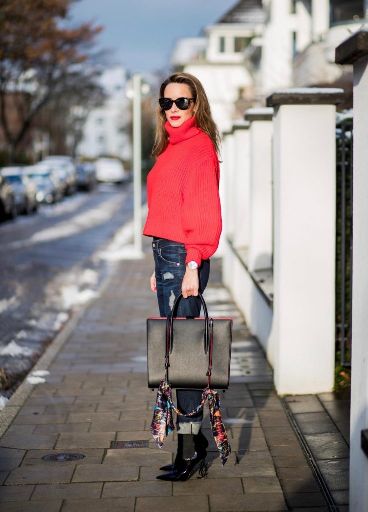 H&M, AG Jeans, Saint Laurent, Christian Louboutin, Dior Alexandra Lapp wearing a cropped red turtleneck from H&M, Adriano Goldschmied Boyfriend denim from AG Jeans, Diormania sunglasses by Dior, Opyum 110 ankle boots in patent from Dior, Paloma medium handbag from Christian Louboutin, IWC watch on December 11, 2017 in Duesseldorf, Germany.
