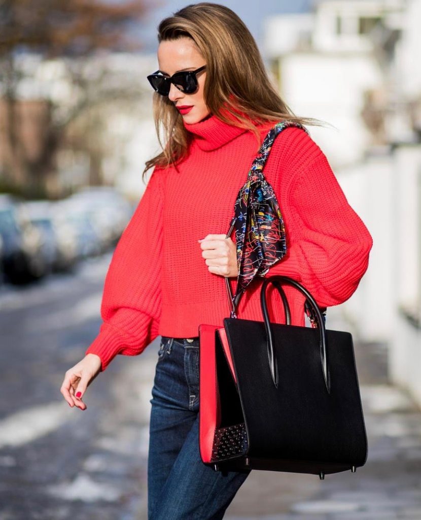 H&M, AG Jeans, Saint Laurent, Christian Louboutin, Dior Alexandra Lapp wearing a cropped red turtleneck from H&M, Adriano Goldschmied Boyfriend denim from AG Jeans, Diormania sunglasses by Dior, Opyum 110 ankle boots in patent from Dior, Paloma medium handbag from Christian Louboutin, IWC watch on December 11, 2017 in Duesseldorf, Germany.