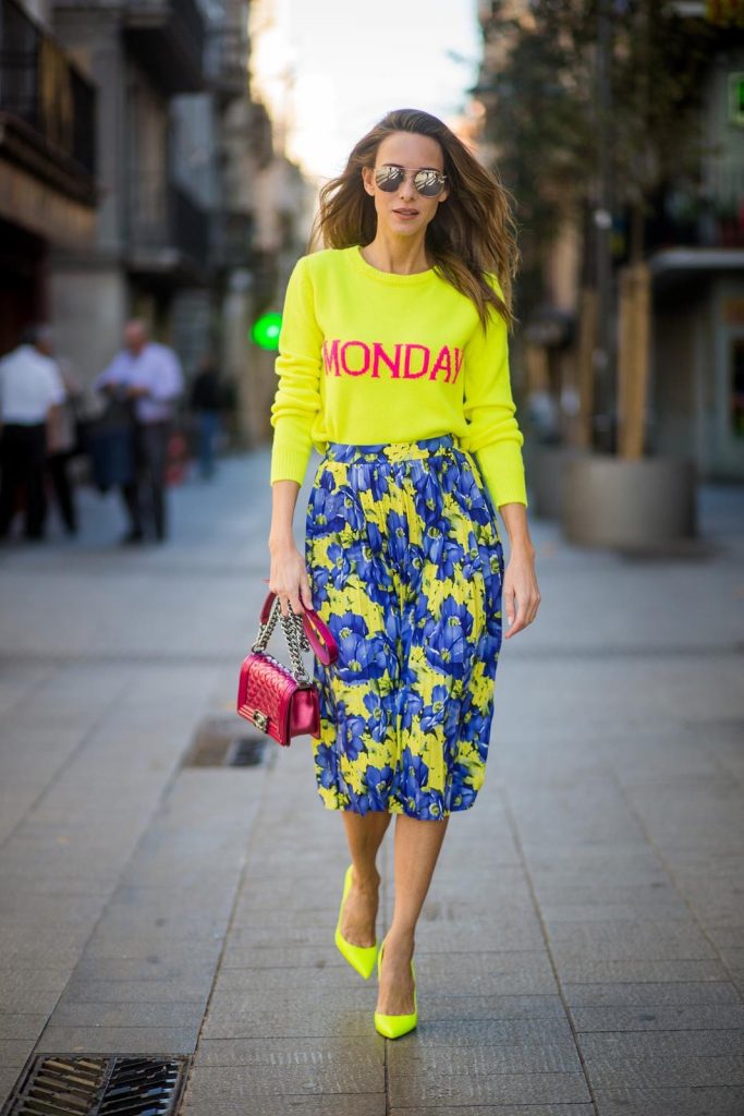 Alexandra Lapp wearing the yellow Alberta Ferretti Monday jumper, pleated skirt with flower prints by Balenciaga, a dark red quilted small boy bag by Chanel, neon yellow pumps by Christian Louboutin and silver Ray Ban sunglasses on November 29, 2017 in Barcelona, Spain.