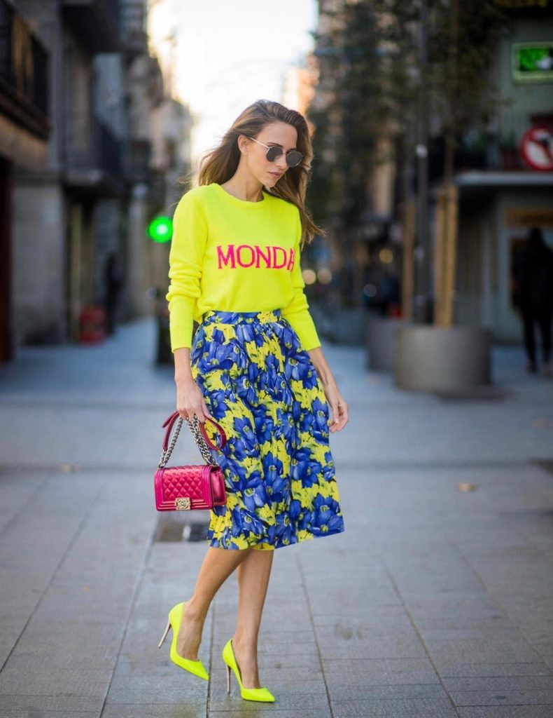 Alexandra Lapp wearing the yellow Alberta Ferretti Monday jumper, pleated skirt with flower prints by Balenciaga, a dark red quilted small boy bag by Chanel, neon yellow pumps by Christian Louboutin and silver Ray Ban sunglasses on November 29, 2017 in Barcelona, Spain.