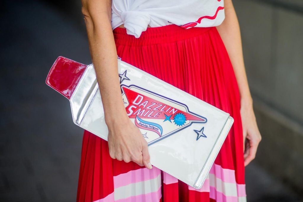 Let us swing - Alexandra Lapp wearing a pleated skirt from Valentino, white t-shirt from Valentino with label print written over the chest with red lipstick, high heel sandals from Sophia Webstar with butterflies on the back, handbag in shape of toothpaste from Yazbukey on November 27, 2017 in Barcelona, Spain.