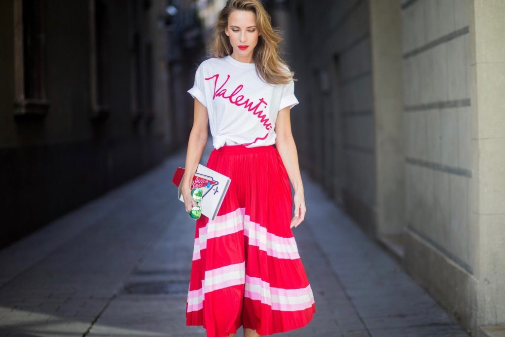 Let us swing - Alexandra Lapp wearing a pleated skirt from Valentino, white t-shirt from Valentino with label print written over the chest with red lipstick, high heel sandals from Sophia Webstar with butterflies on the back, handbag in shape of toothpaste from Yazbukey on November 27, 2017 in Barcelona, Spain.