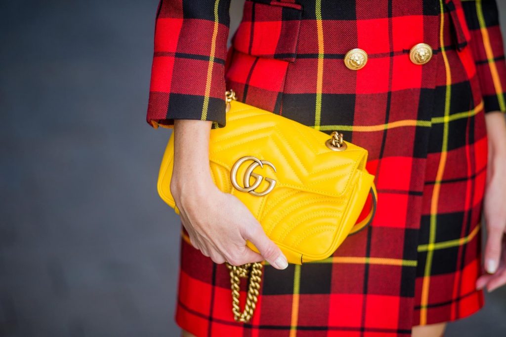 Alexandra Lapp wearing a look all about red, a red checked plaid wool blazer-dress with golden buttons by Balmain, ribbed knit Fendi thigh boots in red Rockoko leather, a yellow Marmont matelasse shoulder bag by Gucci and black Audrey sunglasses by Celine on November 27, 2017 in Barcelona, Spain.
