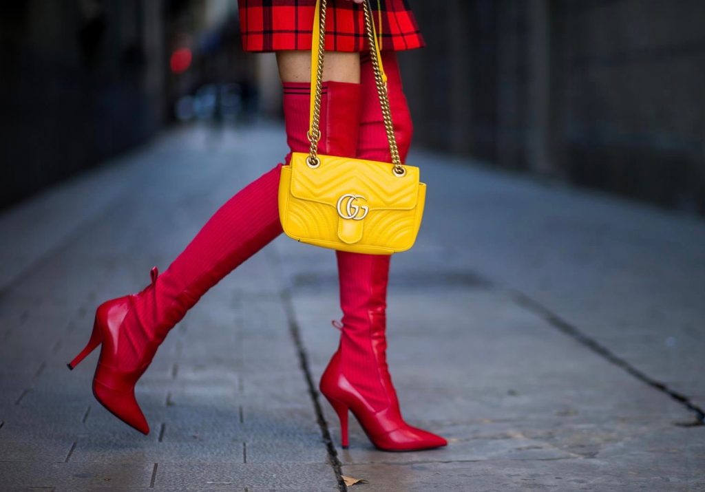 Alexandra Lapp wearing a look all about red, a red checked plaid wool blazer-dress with golden buttons by Balmain, ribbed knit Fendi thigh boots in red Rockoko leather, a yellow Marmont matelasse shoulder bag by Gucci and black Audrey sunglasses by Celine on November 27, 2017 in Barcelona, Spain.