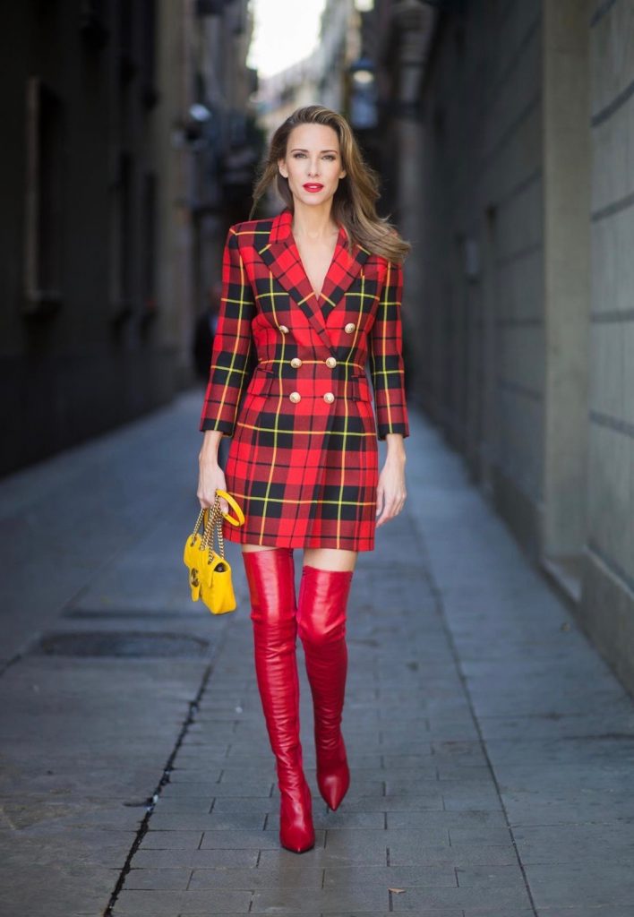 Alexandra Lapp wearing a look all about red, a red checked plaid wool blazer-dress with golden buttons by Balmain, ribbed knit Fendi thigh boots in red Rockoko leather, a yellow Marmont matelasse shoulder bag by Gucci and black Audrey sunglasses by Celine on November 27, 2017 in Barcelona, Spain.