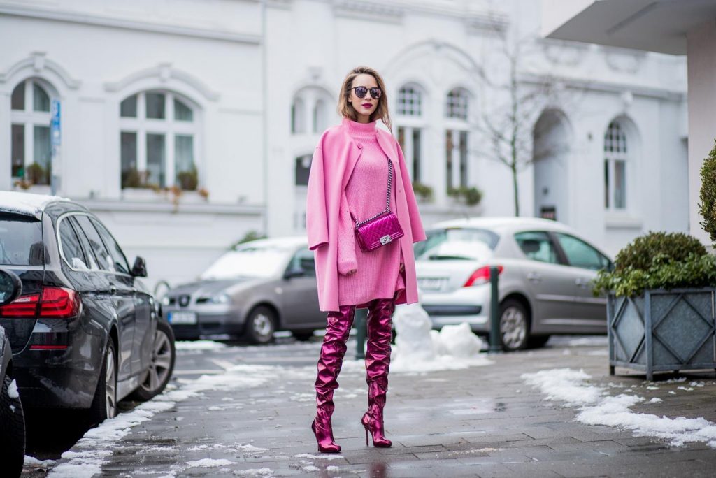 On Wednesdays we wear pink, Alexandra Lapp wearing overknee boots in metallic pink from Christian Louboutin, metallic pink Boy bag from Chanel, pink sunglasses from Le Specs, light pink knit dress from H&M and light pink cashmere coat from Prada on December 10, 2017 in Duesseldorf, Germany.