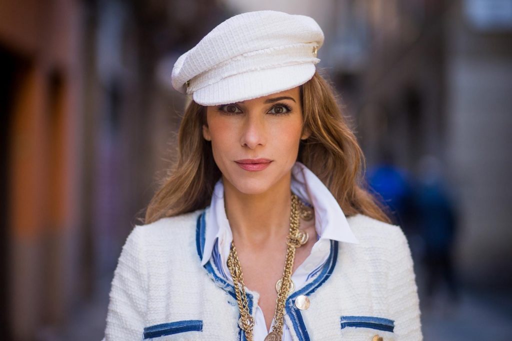 BARCELONA, SPAIN - NOVEMBER 28: Alexandra Lapp wearing a classic navy and white tweed blazer jacket, blue cropped jeans by Steffen Schraut, a white cotton shirt with different shades of blue stripes, denim blue white Louboutin pumps, red Chanel bag, a white cap & vintage gold chains by Chanel on November 28, 2017 in Barcelona, Spain. 