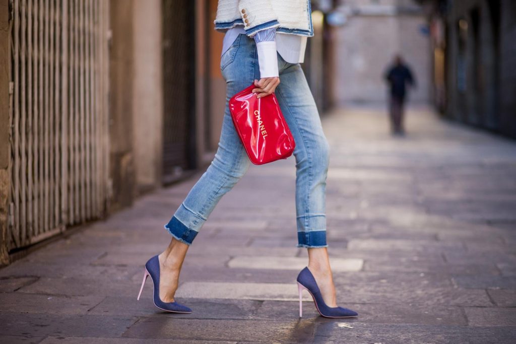 BARCELONA, SPAIN - NOVEMBER 28: Alexandra Lapp wearing a classic navy and white tweed blazer jacket, blue cropped jeans by Steffen Schraut, a white cotton shirt with different shades of blue stripes, denim blue white Louboutin pumps, red Chanel bag, a white cap & vintage gold chains by Chanel on November 28, 2017 in Barcelona, Spain. 