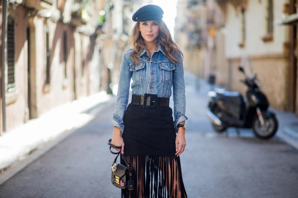 BARCELONA, SPAIN - NOVEMBER 29: Alexandra Lapp wearing a suede leather fringe suede skirt in black from Set Fashion, light blue vintage jeans jacket by Levis, black lacquer waist belt by Gucci, Pigalle Christian Louboutin pumps in black lacquer, MCM shoulder bag and a vintage Chanel cap on November 29, 2017 in Barcelona, Spain.