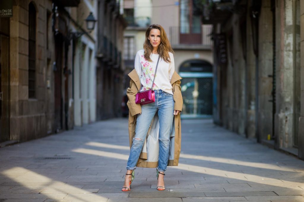 BARCELONA, SPAIN - NOVEMBER 29: Trench coat Hype in Barcelona, Alexandra Lapp wearing and beige oversized egg shaped Audrey trench coat from G-Lab, off-white round neck cashmere pullover with flower applications in pastel tones, vintage Leviss from Re Done, Sophia Webster Chiara sandal heels with a butterfly at the back and Chanel Boy bag in patent pink on November 29, 2017 in Barcelona, Spain.
