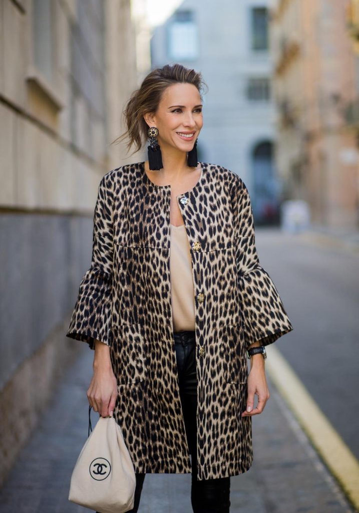 BARCELONA, SPAIN - NOVEMBER 29: Take a walk on the wild side, Alexandra Lapp wearing an animal printed jacket with voluminous bell sleeves by Steffen Schraut, a straight cut silk top in light gold, black skinny leather pants from Current Elliott, sand-black Chanel Mules in suede, black Tassel Earrings by Farina for NA-KD and tote bag in beige from Chanel with Chanel logo on November 29, 2017 in Barcelona, Spain.