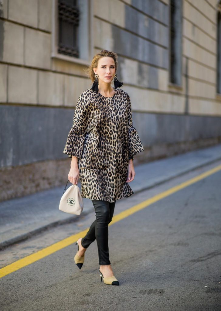 BARCELONA, SPAIN - NOVEMBER 29: Take a walk on the wild side, Alexandra Lapp wearing an animal printed jacket with voluminous bell sleeves by Steffen Schraut, a straight cut silk top in light gold, black skinny leather pants from Current Elliott, sand-black Chanel Mules in suede, black Tassel Earrings by Farina for NA-KD and tote bag in beige from Chanel with Chanel logo on November 29, 2017 in Barcelona, Spain.