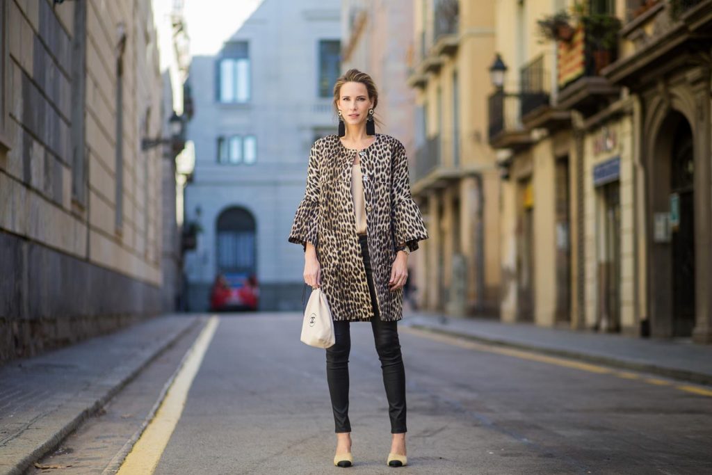BARCELONA, SPAIN - NOVEMBER 29: Take a walk on the wild side, Alexandra Lapp wearing an animal printed jacket with voluminous bell sleeves by Steffen Schraut, a straight cut silk top in light gold, black skinny leather pants from Current Elliott, sand-black Chanel Mules in suede, black Tassel Earrings by Farina for NA-KD and tote bag in beige from Chanel with Chanel logo on November 29, 2017 in Barcelona, Spain.