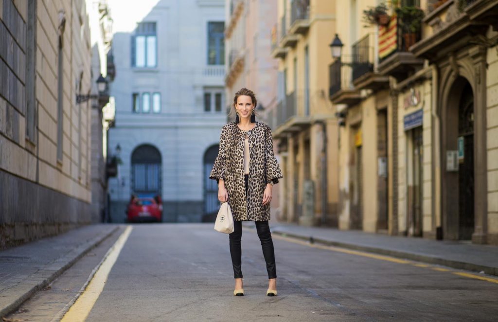 BARCELONA, SPAIN - NOVEMBER 29: Take a walk on the wild side, Alexandra Lapp wearing an animal printed jacket with voluminous bell sleeves by Steffen Schraut, a straight cut silk top in light gold, black skinny leather pants from Current Elliott, sand-black Chanel Mules in suede, black Tassel Earrings by Farina for NA-KD and tote bag in beige from Chanel with Chanel logo on November 29, 2017 in Barcelona, Spain.