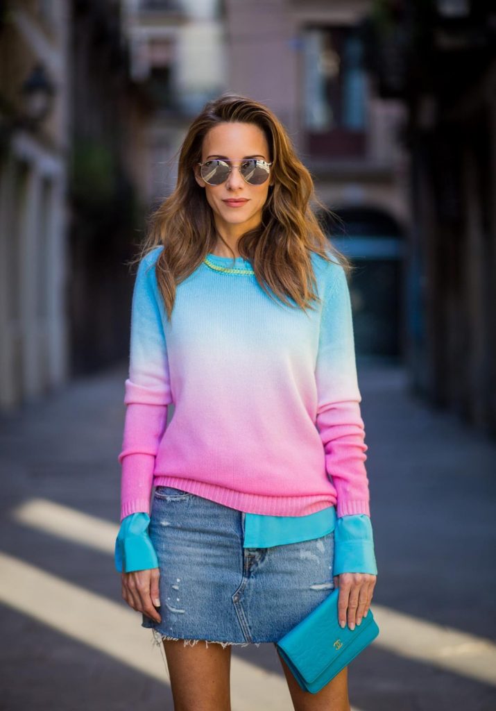 Alexandra Lapp wearing shades of pastels, a mini jeans skirt from Levis, batik cashmere pullover from Heartbreaker in turquoise and pink, Equipment silk blouse in turquoise, little purse bag from Chanel with golden Chanel sign, silver mirrored sunglasses from Le Specs and pink patent So Kate heels from Christian Louboutin on November 28, 2017 in Barcelona, Spain. 