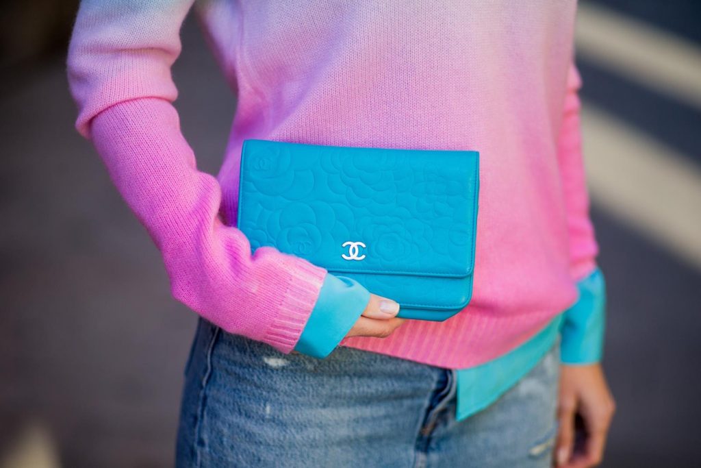 Alexandra Lapp wearing shades of pastels, a mini jeans skirt from Levis, batik cashmere pullover from Heartbreaker in turquoise and pink, Equipment silk blouse in turquoise, little purse bag from Chanel with golden Chanel sign, silver mirrored sunglasses from Le Specs and pink patent So Kate heels from Christian Louboutin on November 28, 2017 in Barcelona, Spain. 