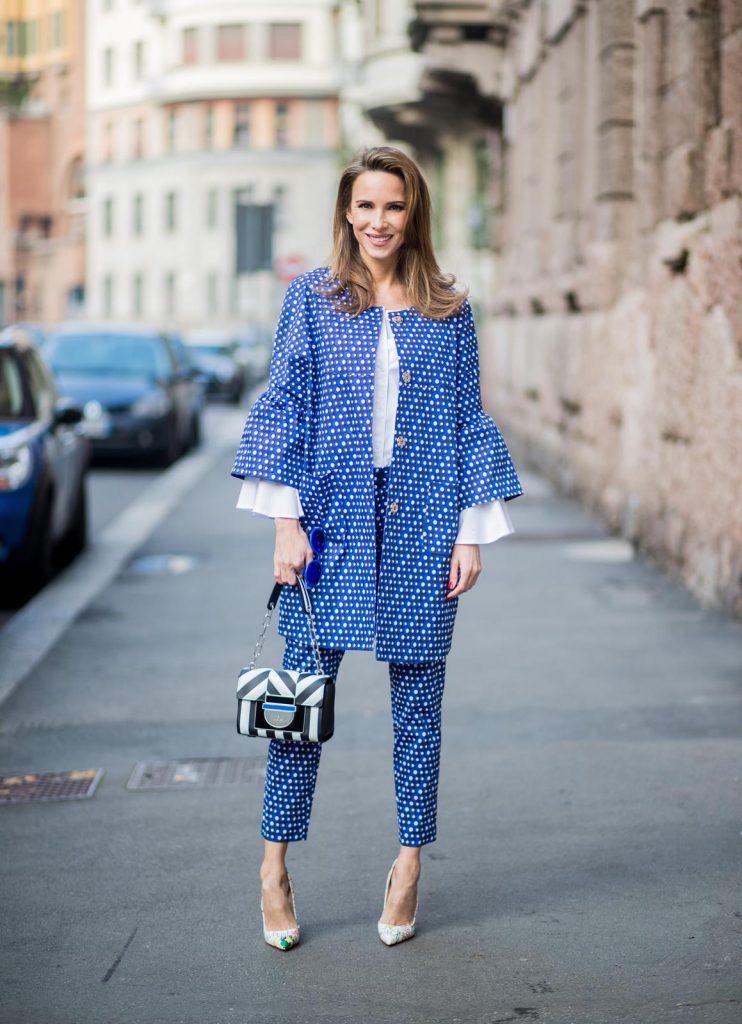 MILAN, ITALY - FEBRUARY 21: Alexandra Lapp wearing dots and stripes, blue trousers with white dots and a matching jacket with a wider short sleeve and a long white blouse from Steffen Schraut, Aigner bag, white pumps from Christian Louboutin seen during Milan Fashion Week Fall/Winter 2018/19 on February 21, 2018 in Milan, Italy.
