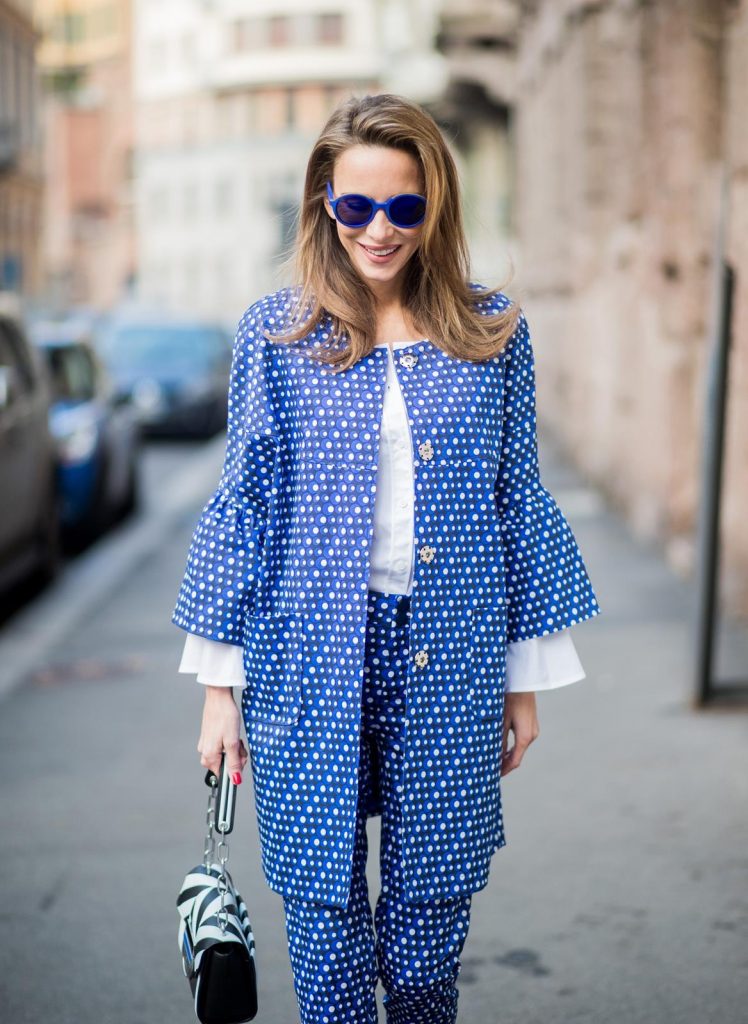 MILAN, ITALY - FEBRUARY 21: Alexandra Lapp wearing dots and stripes, blue trousers with white dots and a matching jacket with a wider short sleeve and a long white blouse from Steffen Schraut, Aigner bag, white pumps from Christian Louboutin seen during Milan Fashion Week Fall/Winter 2018/19 on February 21, 2018 in Milan, Italy.