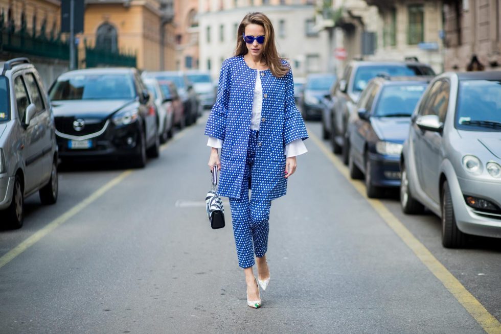 MILAN, ITALY - FEBRUARY 21: Alexandra Lapp wearing dots and stripes, blue trousers with white dots and a matching jacket with a wider short sleeve and a long white blouse from Steffen Schraut, Aigner bag, white pumps from Christian Louboutin seen during Milan Fashion Week Fall/Winter 2018/19 on February 21, 2018 in Milan, Italy.