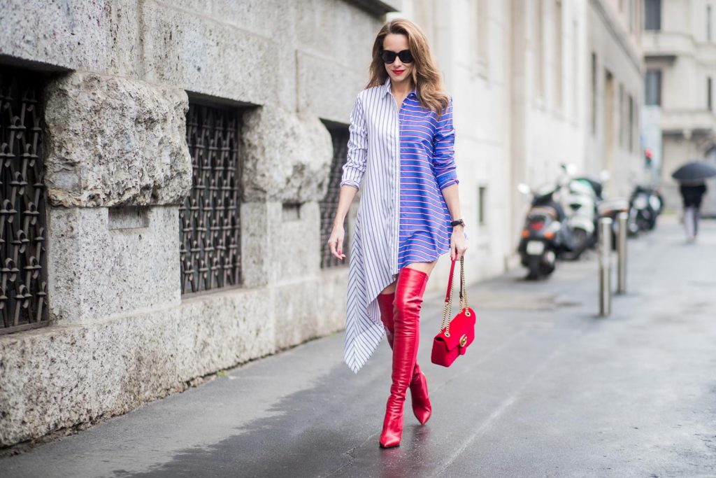 Alexandra Lapp wearing an asymmetric striped blouse by Off-white, red leather over knee boots from Fendi, a red velvet Gucci Marmont handbag with a golden chain and black sunglasses from Celine seen during Milan Fashion Week Fall/Winter 2018/19 on February 24, 2018 in Milan, Italy.
