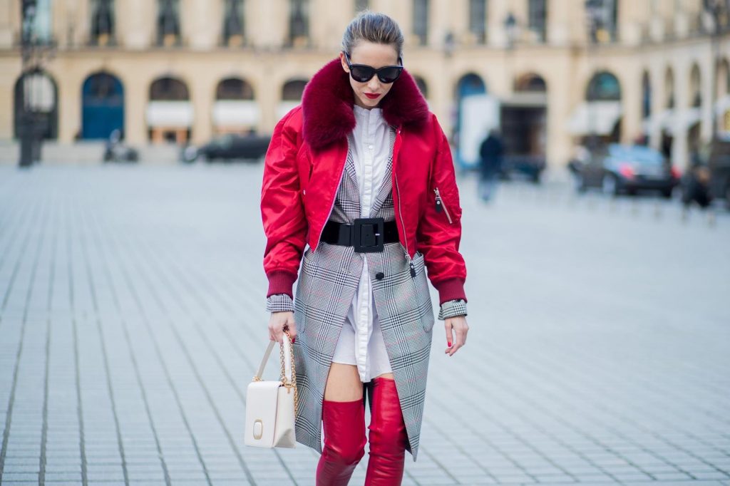 Alexandra Lapp wearing a glencheck coat from Set Fashion, red leather over knee boots from Fendi, a white long shirt from Dorothee Schumacher, a black waist belt from Dolce & Gabbana, a red short bomber jacket with a dark red fur collar from Yves Salomon, off white Madame Viv bag from Roger Vivier and black sunglasses from Celine is seen on February 28, 2018 in Paris, France.