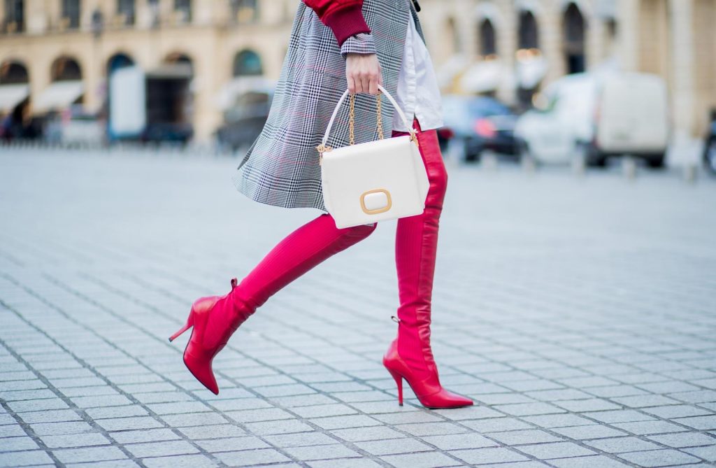Alexandra Lapp wearing a glencheck coat from Set Fashion, red leather over knee boots from Fendi, a white long shirt from Dorothee Schumacher, a black waist belt from Dolce & Gabbana, a red short bomber jacket with a dark red fur collar from Yves Salomon, off white Madame Viv bag from Roger Vivier and black sunglasses from Celine is seen on February 28, 2018 in Paris, France.