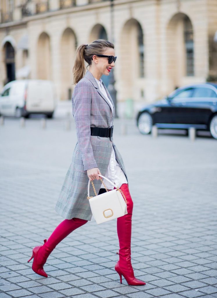 Alexandra Lapp wearing a glencheck coat from Set Fashion, red leather over knee boots from Fendi, a white long shirt from Dorothee Schumacher, a black waist belt from Dolce & Gabbana, a red short bomber jacket with a dark red fur collar from Yves Salomon, off white Madame Viv bag from Roger Vivier and black sunglasses from Celine is seen on February 28, 2018 in Paris, France.