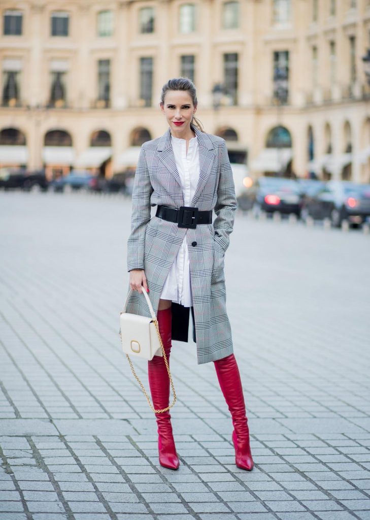 Alexandra Lapp wearing a glencheck coat from Set Fashion, red leather over knee boots from Fendi, a white long shirt from Dorothee Schumacher, a black waist belt from Dolce & Gabbana, a red short bomber jacket with a dark red fur collar from Yves Salomon, off white Madame Viv bag from Roger Vivier and black sunglasses from Celine is seen on February 28, 2018 in Paris, France.