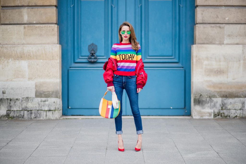 Alberta Ferretti, Yves Salomon, Adriano Goldschmied, MCM, Ray Ban, Gianvito Rossi PARIS, FRANCE - FEBRUARY 28: Alexandra Lapp wearing Pullover Alberta Ferretti with today print, AG Jeans denim, Bag MCM Patricia Hobo bag in striped Canvas, Aviator Sunglasses in green from Ray Ban, Heels Gianvito Rossi in patent red, jacket Yves Salomon is seen on February 28, 2018 in Paris, France.
