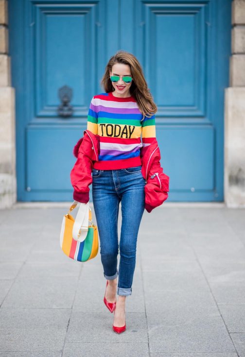 PARIS, FRANCE - FEBRUARY 28: Alexandra Lapp wearing Pullover Alberta Ferretti with today print, AG Jeans denim, Bag MCM Patricia Hobo bag in striped Canvas, Aviator Sunglasses in green from Ray Ban, Heels Gianvito Rossi in patent red, jacket Yves Salomon is seen on February 28, 2018 in Paris, France.