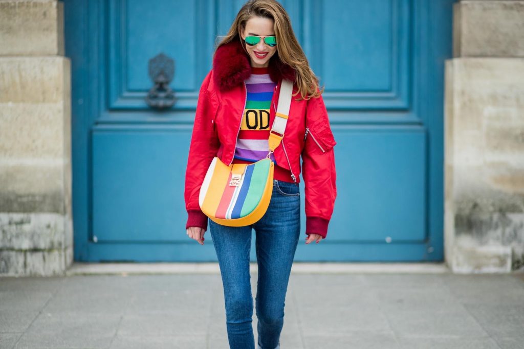 Alberta Ferretti, Yves Salomon, Adriano Goldschmied, MCM, Ray Ban, Gianvito Rossi PARIS, FRANCE - FEBRUARY 28: Alexandra Lapp wearing Pullover Alberta Ferretti with today print, AG Jeans denim, Bag MCM Patricia Hobo bag in striped Canvas, Aviator Sunglasses in green from Ray Ban, Heels Gianvito Rossi in patent red, jacket Yves Salomon is seen on February 28, 2018 in Paris, France.