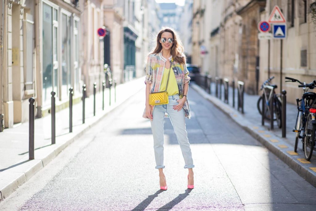 Airfield, Jadicted, Chanel, Le Specs, Christian Louboutin, IWC PARIS, FRANCE - MARCH 02: Alexandra Lapp wearing pastel tweed, a long tweed blazer in pastel colors from Airfield, a silk top in bright yellow from Jadicted, light blue boyfriend jeans by Airfield, a neon yellow Chanel bag, neon pink high heels from Christian Louboutin and sunglasses from Le Specs is seen on March 2, 2018 in Paris, France.
