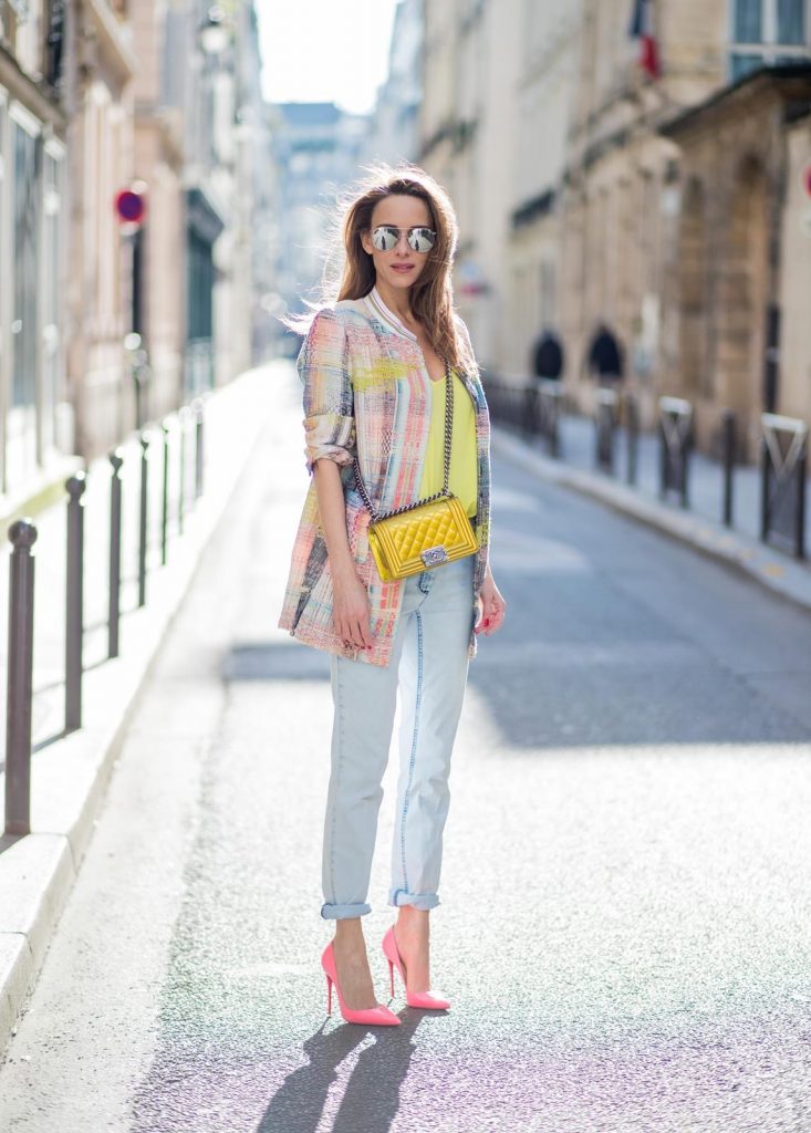 Airfield, Jadicted, Chanel, Le Specs, Christian Louboutin, IWC PARIS, FRANCE - MARCH 02: Alexandra Lapp wearing pastel tweed, a long tweed blazer in pastel colors from Airfield, a silk top in bright yellow from Jadicted, light blue boyfriend jeans by Airfield, a neon yellow Chanel bag, neon pink high heels from Christian Louboutin and sunglasses from Le Specs is seen on March 2, 2018 in Paris, France.