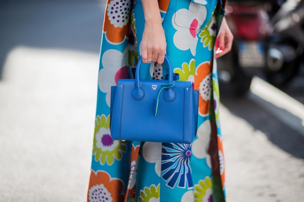 Alexandra Lapp in Seventies Style wearing flower power silk jacquard pants in multicolor with a long leg by Talbot Runhof with matching long vest made of flower power jacquard in multicolor, white silk shirt from Jadicted, blue neo Milla tote bag, Pigalle Follies pumps by Christian Louboutin and blue round sunglasses from Mykita seen during Milan Fashion Week Fall/Winter 2018/19 on February 21, 2018 in Milan, Italy.