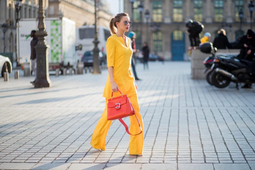 Talbot Runhof, Roger Vivier, Christian Louboutin, Le Specs Alexandra Lapp wearing taroni silk pants & a tunic in yellow from Talbot & Runhof, small Viv Cabas in orange with shoulder strap, mirrored sunglasses from Le Specs and Christian Louboutin So Kate Pumps is seen on February 28, 2018 in Paris, France.