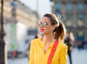 Alexandra Lapp wearing taroni silk pants & a tunic in yellow from Talbot & Runhof, small Viv Cabas in orange with shoulder strap, mirrored sunglasses from Le Specs and Christian Louboutin So Kate Pumps is seen on February 28, 2018 in Paris, France.