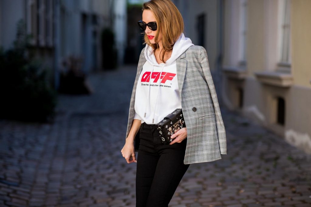 Off-White, Anine Bing, Mother, Christian Louboutin, Louis Vuitton, Dior Alexandra Lapp wearing the Off-White Hoodie c/o Virgil Abloh 0777 cotton Terry Hoodie in white, multicolored plaid Madeleine blazer by Anine Bing, the Cha Cha Fray flared pants in black by Mother, black patent leather pumps by Christian Louboutin, a black Petite Malle with silver accessories by Louis Vuitton and black Diormania sunglasses by Dior on May 6, 2018 in Duesseldorf, Germany.