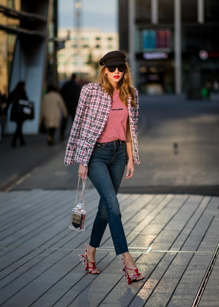 Alexandra Lapp wearing a striped shirt look with Saint Laurent Logo jersey T-Shirt in red-white, a white/blue/red Tweed Jacket by Balmain, dark blue Levis Super Skinny jeans, Prada flame shoes, the Chanel Perfume Bottle Bag in clear plexiglass, vintage Chanel Bakerboy cap and black Celine sunglasses on May 3, 2018 in Duesseldorf, Germany.