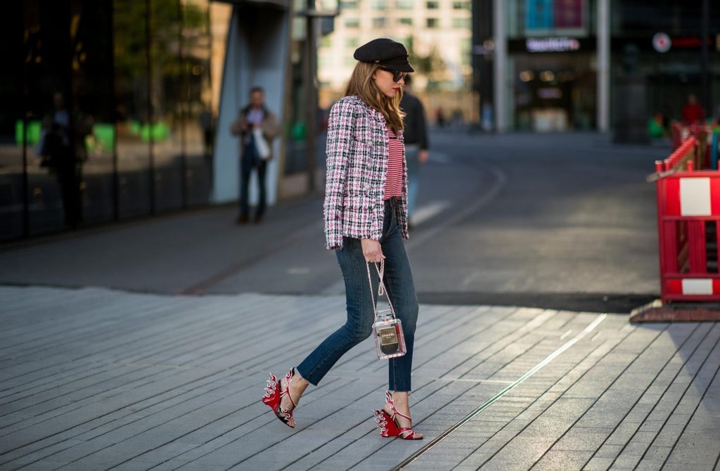 Alexandra Lapp wearing a striped shirt look with Saint Laurent Logo jersey T-Shirt in red-white, a white/blue/red Tweed Jacket by Balmain, dark blue Levis Super Skinny jeans, Prada flame shoes, the Chanel Perfume Bottle Bag in clear plexiglass, vintage Chanel Bakerboy cap and black Celine sunglasses on May 3, 2018 in Duesseldorf, Germany.