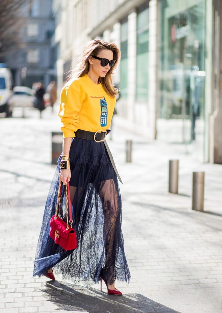 Wodka Ogurez, Self-Portrait, Dorothee Schumacher, Gucci, Gianvito Rossi, Chanel, Céline Alexandra Lapp in handmade print Wodka Ogurez sweater in yellow with handmade Nokia phone print, long dark blue Self-Portrait lace dress underneath, Dorothee Schumacher waist belt with big golden buckle, red patent Gianvito Rossi pumps, Chanel bracelet with golden CC sign, golden vintage Chanel bracelet, red velvet Gucci Marmont bag and Celine Audrey sunglasses during Paris Fashion Week Womenswear Fall/Winter 2018/2019 on March 3, 2018 in Paris, France.