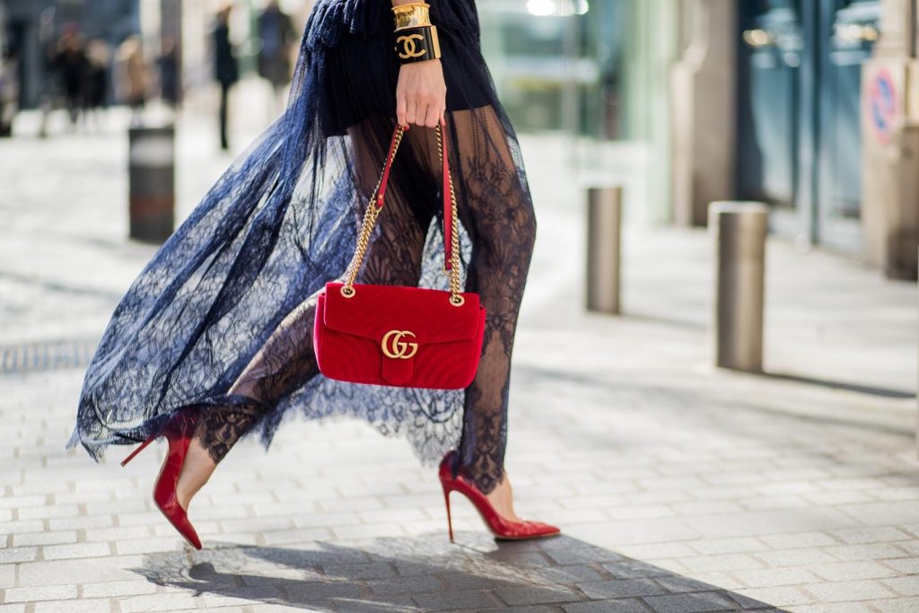 Wodka Ogurez, Self-Portrait, Dorothee Schumacher, Gucci, Gianvito Rossi, Chanel, Céline Alexandra Lapp in handmade print Wodka Ogurez sweater in yellow with handmade Nokia phone print, long dark blue Self-Portrait lace dress underneath, Dorothee Schumacher waist belt with big golden buckle, red patent Gianvito Rossi pumps, Chanel bracelet with golden CC sign, golden vintage Chanel bracelet, red velvet Gucci Marmont bag and Celine Audrey sunglasses during Paris Fashion Week Womenswear Fall/Winter 2018/2019 on March 3, 2018 in Paris, France.