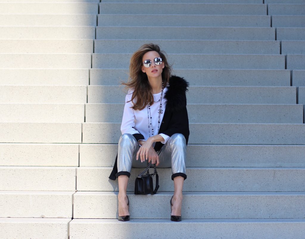 Airfield, Chanel, Le Specs, Jadicted, Christian Louboutin Model and Blogger Alexandra Lapp wearing silver denim pants from Airfield, black knit and fur cape from Airfield, black Boy Bag from Chanel, Chanel vintage necklace, silver sunglasses by Le Specs, white silk shirt from Jades and black lacquer Pigalle pumps from Christian Louboutin.