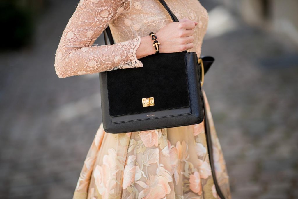 Alexandra Lapp wearing a pastel floral dress as seen in a lace embroidered mini dress by Lana Mueller, a gold buckle belt by Dorothee Schuhmacher, a numero deux edition in trio black by Polène, black Christian Louboutin pumps, black Celine sunglasses and a black leather bracelet by Coerlys on May 4, 2018 in Duesseldorf, Germany.