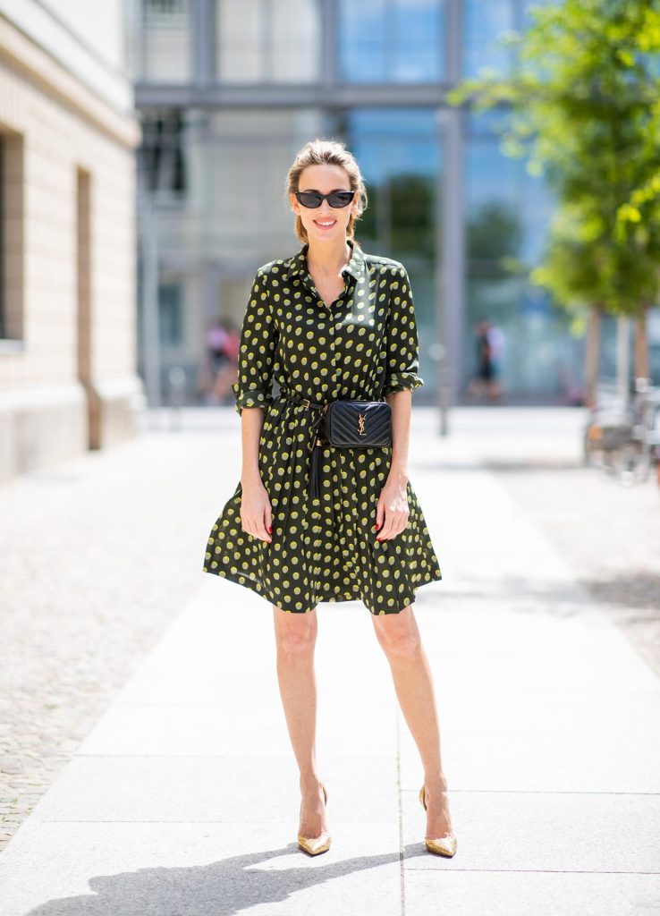 Steffen Schraut, Saint Laurent, Christian Louboutin, State Optical Co. Alexandra Lapp is seen in a Waist Belt Bag Look wearing a knee length dark green dress with green and yellow dots from Steffen Schraut, the Lou Belt Bag in black by Saint Laurent, the golden Iriza glitter pumps by Christian Louboutin and two tone sunglasses from State x Cotw in black white on July 13, 2018 in Berlin, Germany.
