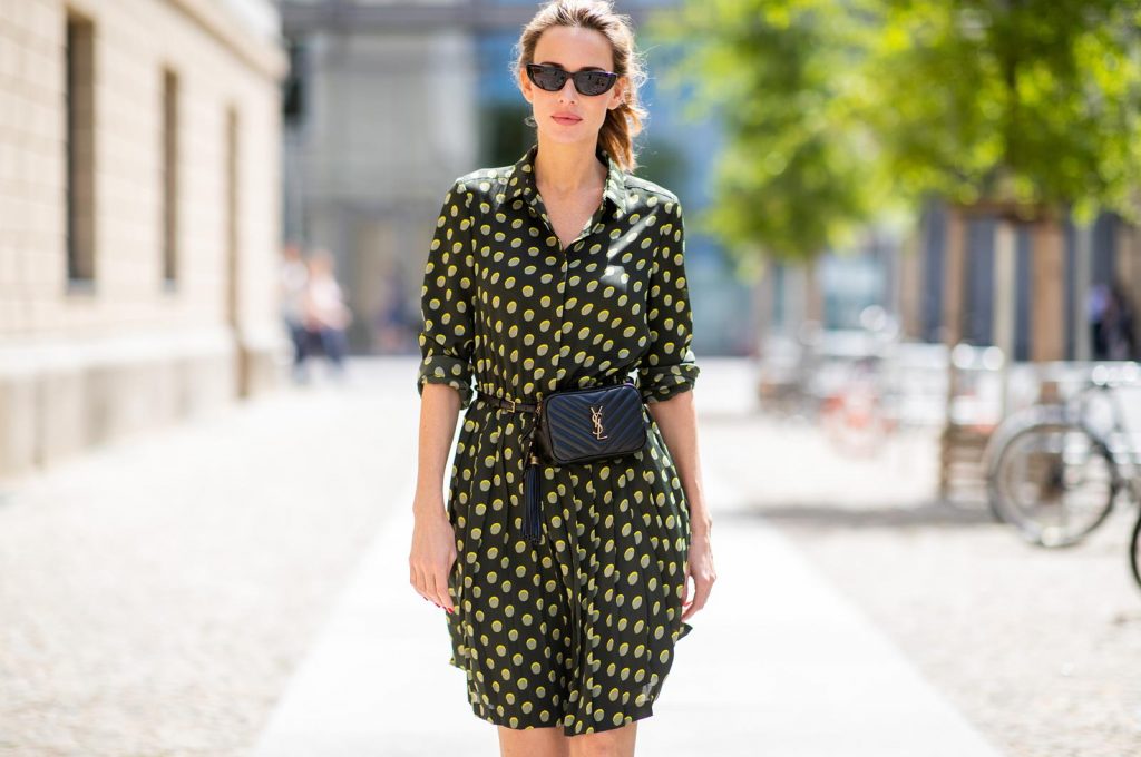 Steffen Schraut, Saint Laurent, Christian Louboutin, State Optical Co. Alexandra Lapp is seen in a Waist Belt Bag Look wearing a knee length dark green dress with green and yellow dots from Steffen Schraut, the Lou Belt Bag in black by Saint Laurent, the golden Iriza glitter pumps by Christian Louboutin and two tone sunglasses from State x Cotw in black white on July 13, 2018 in Berlin, Germany.