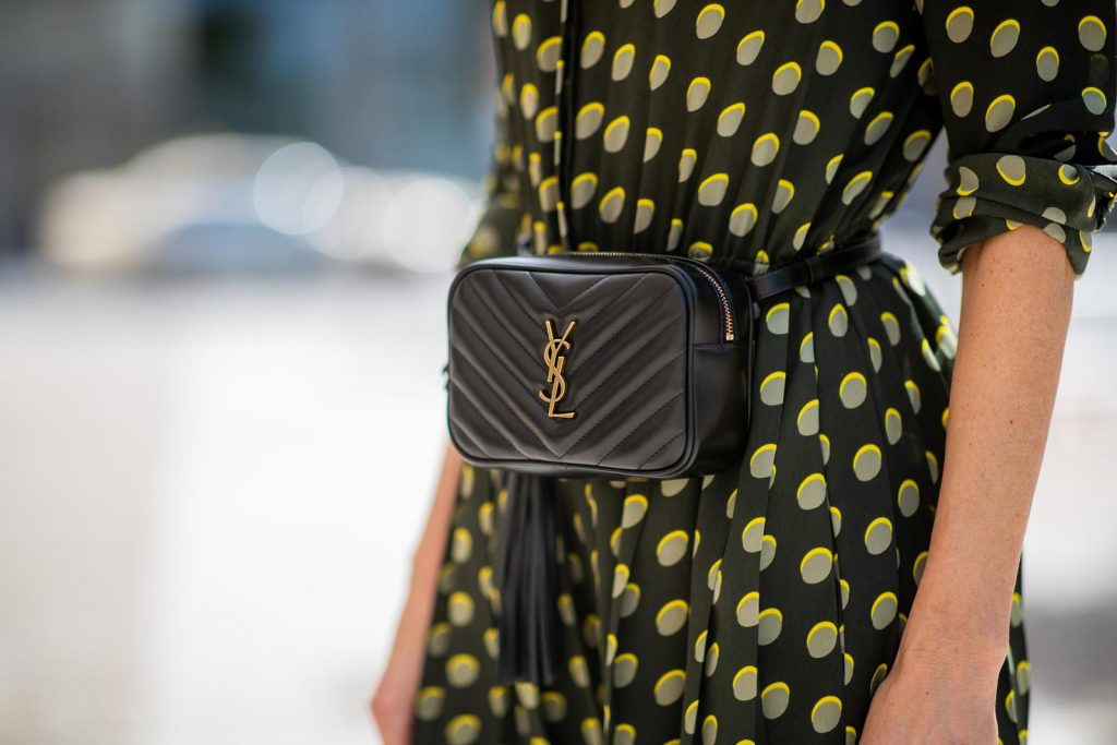 Steffen Schraut, Saint Laurent, Christian Louboutin, State Optical Co. Alexandra Lapp is seen in a Waist Belt Bag Look wearing a knee length dark green dress with green and yellow dots from Steffen Schraut, the Lou Belt Bag in black by Saint Laurent, the golden Iriza glitter pumps by Christian Louboutin and two tone sunglasses from State x Cotw in black white on July 13, 2018 in Berlin, Germany.
